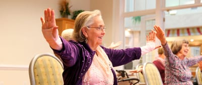 Residents participating in a seated exercise class