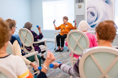 Residents participating in a light exercise class indoors