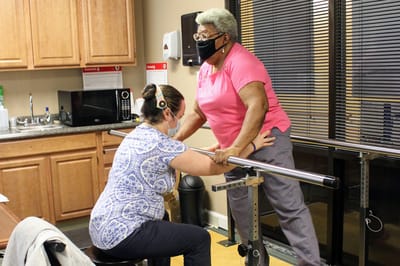 Staff assisting a resident with therapy exercises