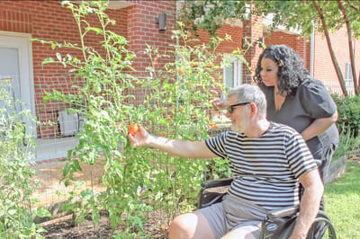Resident and staff member enjoying gardening outdoors
