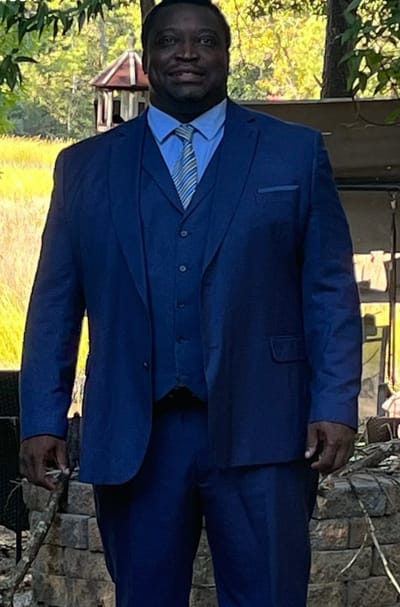 A man in a blue suit standing outdoors