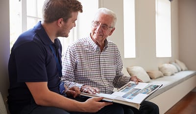 A caregiver and resident sharing memories in a common area