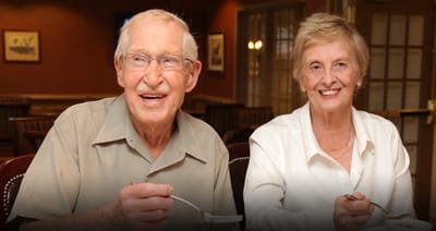 Two residents enjoying a meal in the dining room