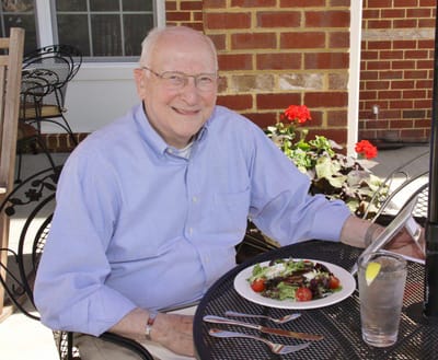 An elderly resident enjoying a meal outdoors