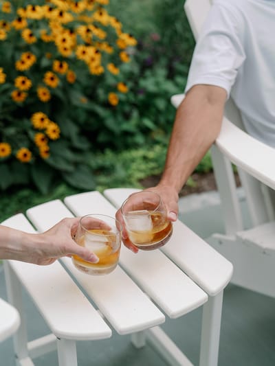 Two glasses clinking in a garden setting