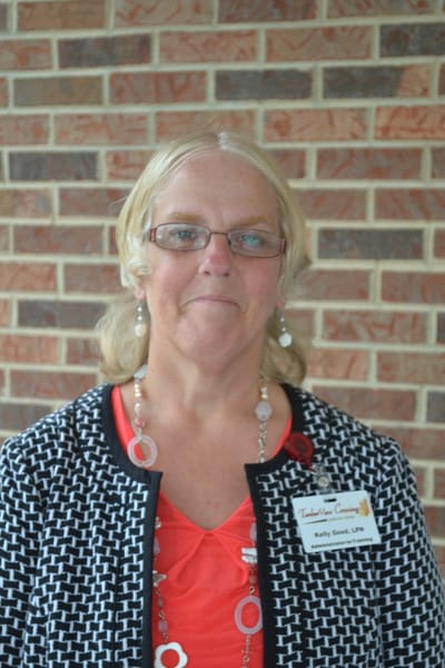 Staff member in front of a brick wall