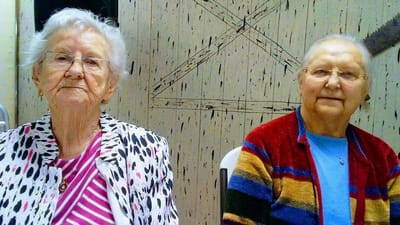 Two elderly women sitting together in a social setting