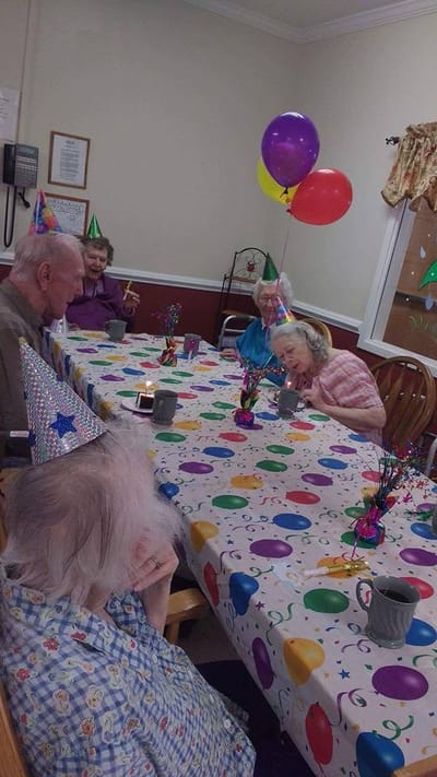 Residents celebrating with party hats and balloons