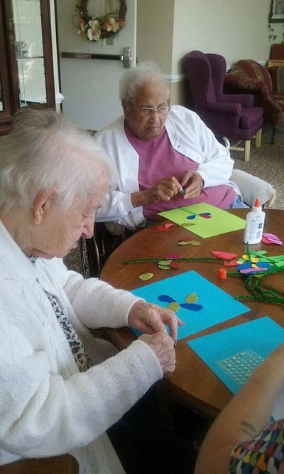 Residents engaged in a craft activity at a table