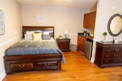 Cozy interior view of a resident room with a bed and kitchenette