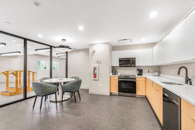 A bright kitchen area with a dining table and appliances