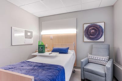 Cozy interior view of a resident room with a bed and chair