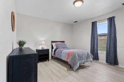 Brightly decorated private resident room with bed and dresser
