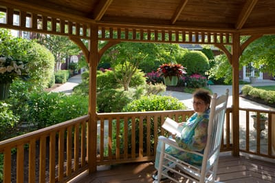 Resident enjoying a book in an outdoor gazebo