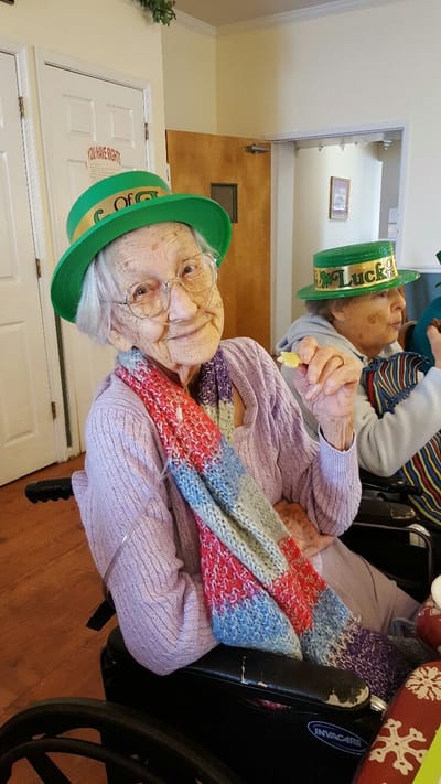 Resident celebrating with St. Patrick's Day hat and smile