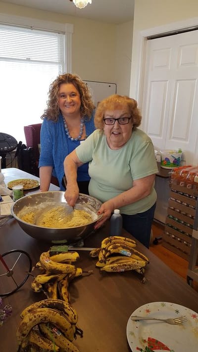 Residents and staff baking together in a kitchen