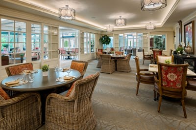 Bright dining area with round tables and wicker chairs