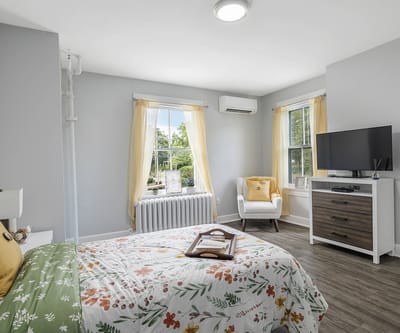 Cozy resident room with floral bedding and sunlight