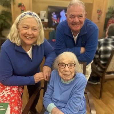 Residents and staff smiling together in a common area