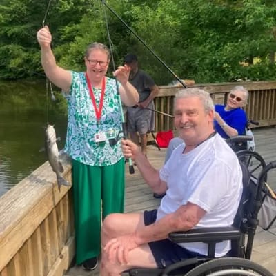 Residents fishing by the water with staff assistance