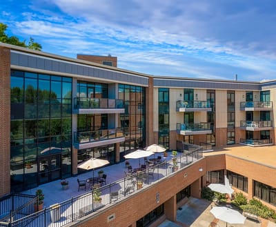 Exterior view of a senior living facility with outdoor seating