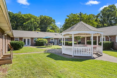 Outdoor gazebo surrounded by lawn and buildings