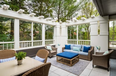 Stylish sunroom with seating and greenery