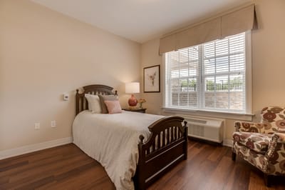 Cozy interior of a resident's room with a bed and chair