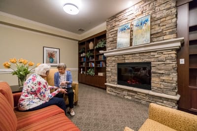 Two residents talking in a cozy lounge area