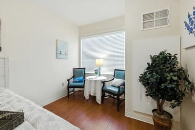 Cozy resident room with seating and a lamp