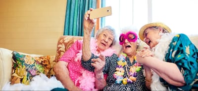 Three elderly women enjoying a fun moment while taking a selfie