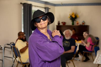 Resident in a purple outfit and sunglasses enjoying activities.