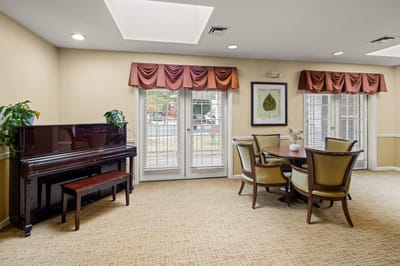 Interior view of a common area with a piano and dining table