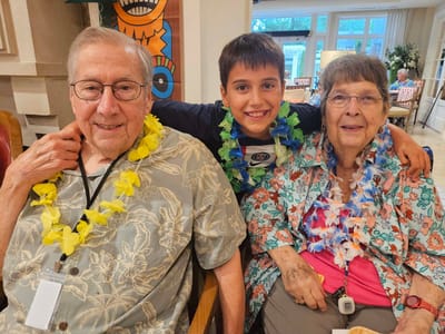 Residents celebrating with leis and a child