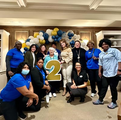 Staff and residents celebrating in a decorated common area