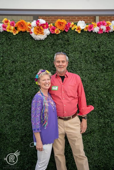 Two residents smiling at a festive event backdrop