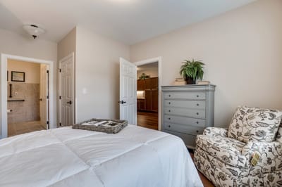 A cozy resident room with a bed and chair
