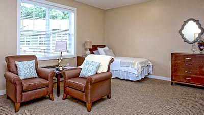 Cozy resident room with armchairs and bed