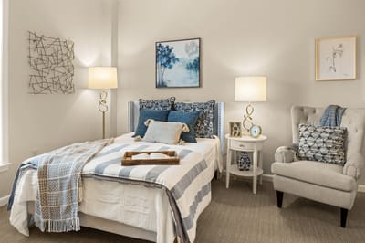 A cozy, well-decorated resident room with a bed and lamps