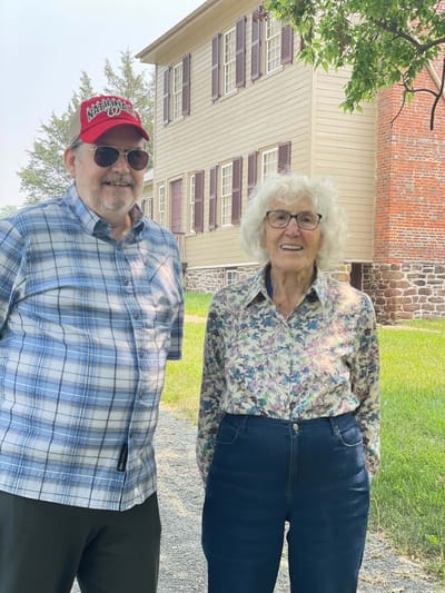 Two residents smiling outdoors near the facility