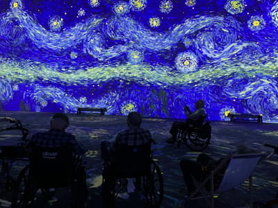 Residents enjoying an art display in wheelchairs