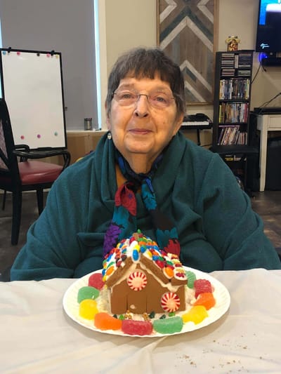 Resident enjoying a decorated gingerbread house activity