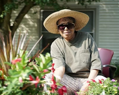 A resident tending to flowers in a garden