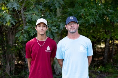 Two men standing outdoors in Pinecrest shirts