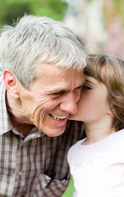 An elderly man and a young girl sharing a joyful moment