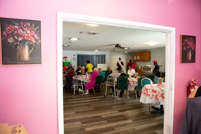 Interior view of a dining room with residents and staff