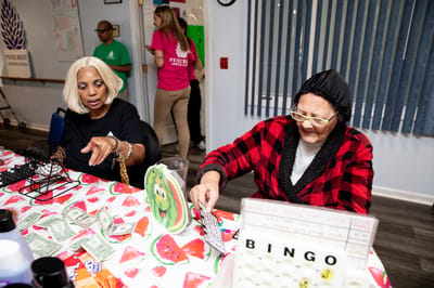 Residents playing bingo in a colorful activity room