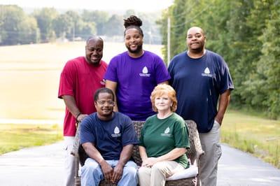 Staff members smiling outdoors in a relaxed pose