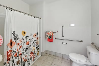 Bright, modern bathroom interior with floral shower curtain