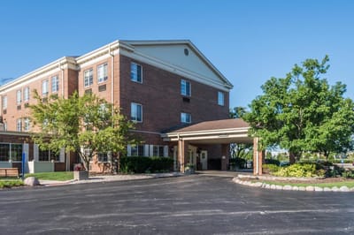 Exterior view of a senior living facility with landscaped area